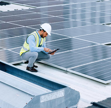 Engineer or contractor measuring solar panels on a roof of a building